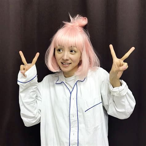 A Woman With Pink Hair Is Making The Peace Sign