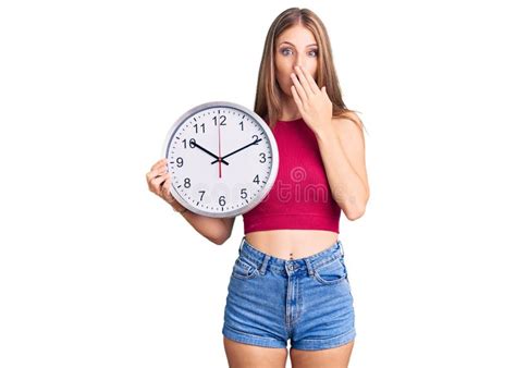 Jeune Belle Femme Blonde Tenant Grande Horloge Couvrant La Bouche Avec La Main Choqu E Et Peur