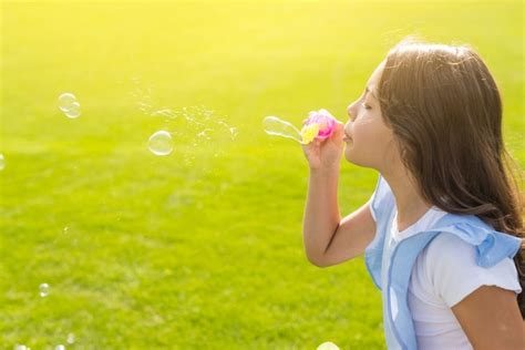 Fille de côté faisant des bulles de savon à l extérieur Photo Gratuite