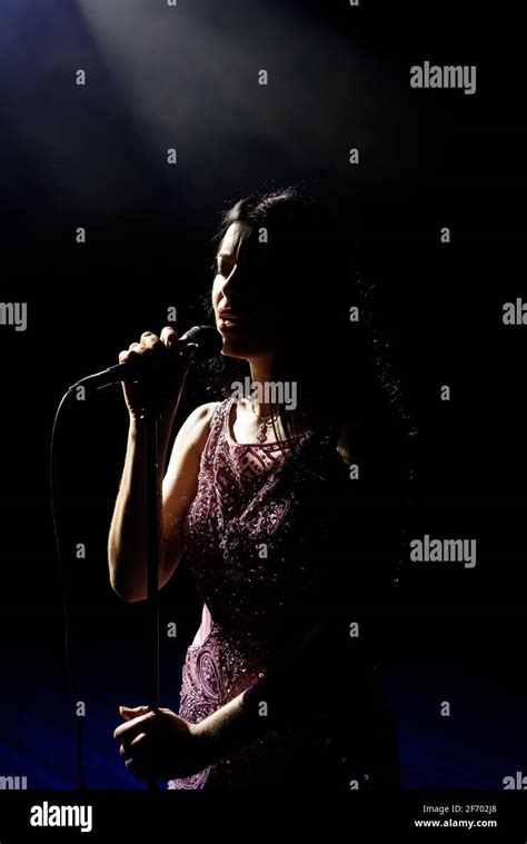 Portrait of beautiful singing woman on dark background Stock Photo - Alamy