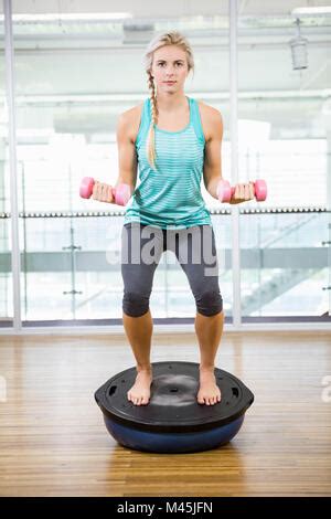 Monter blonde standing sur bosu ball et de soulever les haltères Photo Stock Alamy