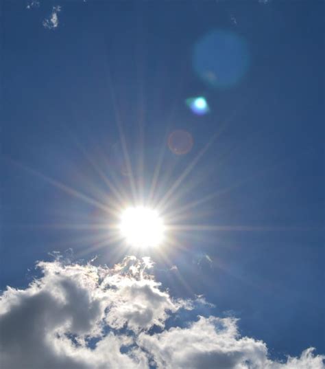 Premium Photo Low Angle View Of Sun Shining Through Clouds