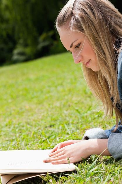 Jeune Fille Blonde Allong E Sur L Herbe En Lisant Un Livre Photo Premium