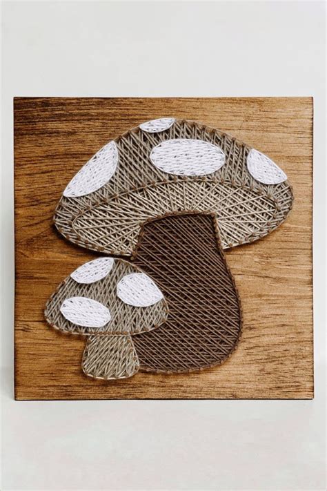 A Large And Small Mushroom Made In String Art Using Dark And Light