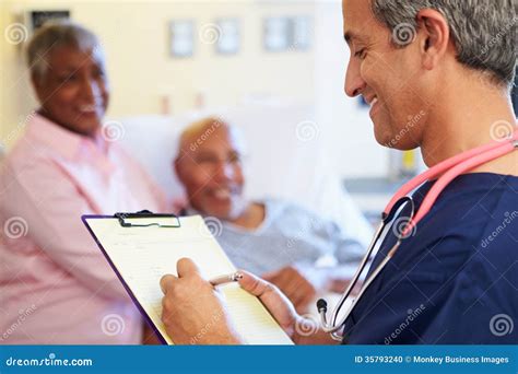 Close Up Of Male Nurse Updating Patient Notes Stock Photo Image Of