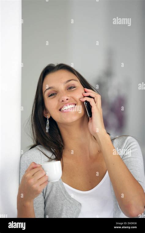 Brunette Chatting To Friends On The Phone Whilst Drinking Coffee Stock