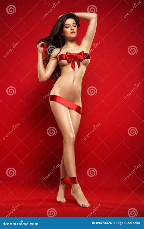 Beautiful Naked Woman Wrapped With Red Gift Ribbon Posing Isolated On