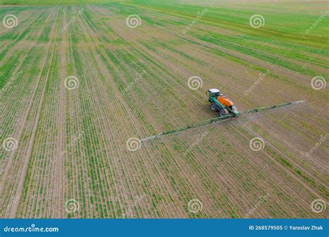 Trator Pulveriza O Campo Fertilizante Ou Herbicida Imagem De Stock