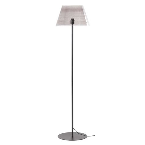 A Floor Lamp With A White Shade On The Top And A Black Base Against A