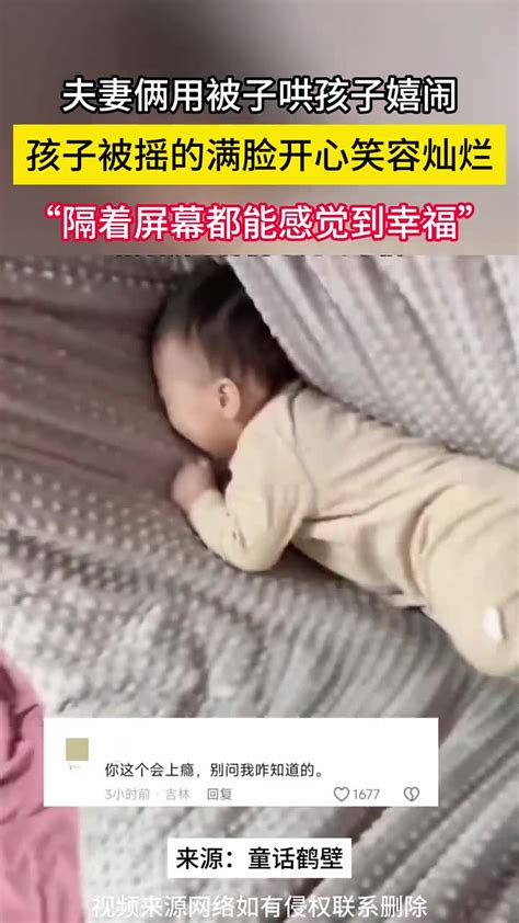 夫妻俩用被子哄孩子嬉闹。孩子被摇的满脸开心笑容灿烂