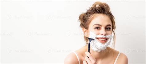 Portrait of beautiful young smiling caucasian woman shaves face with ...