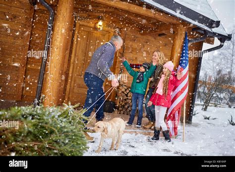 Happy family with Christmas tree on winter holiday Stock Photo - Alamy