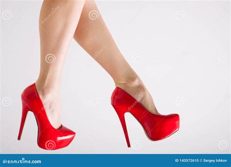 Piernas Femeninas Perfectas Que Llevan Los Tacones Altos Rojos En El