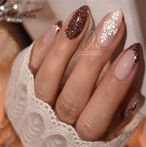 A Manicure With Gold Glitters And Snowflakes On The Tip Of It