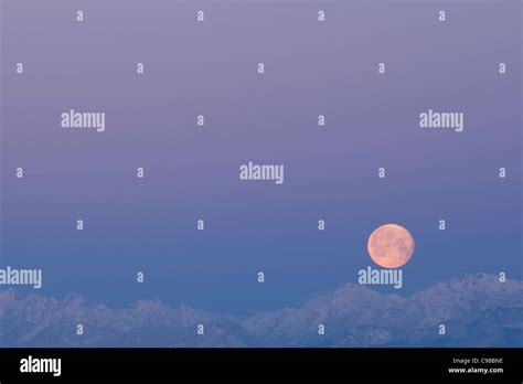 Sunrise with moon set over snow covered Olympic Mountains Stock Photo ...