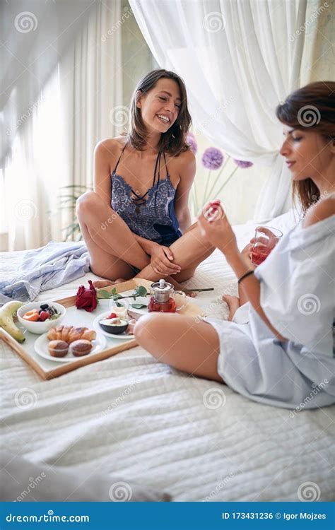 Lesbians Sitting Legs Crossed Breakfast In Bed Talking Smiling