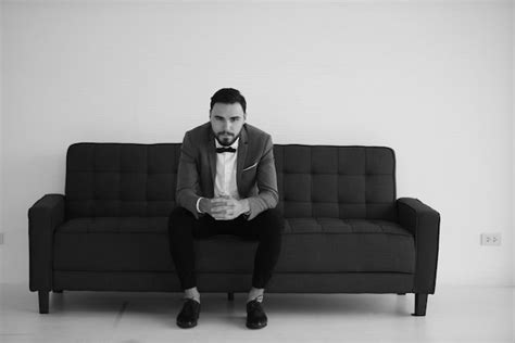 Premium Photo Full Length Portrait Of Young Man Sitting On Sofa At Home