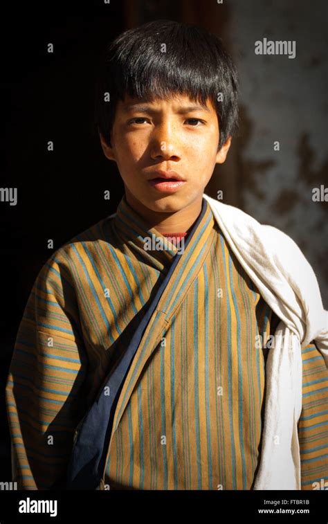 Portrait Of A Young Bhutanese Boy Wearing A Traditional Striped Gho