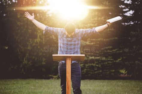 Un Hombre Joven Con Las Manos Alzadas Sosteniendo La Biblia Cerca Del