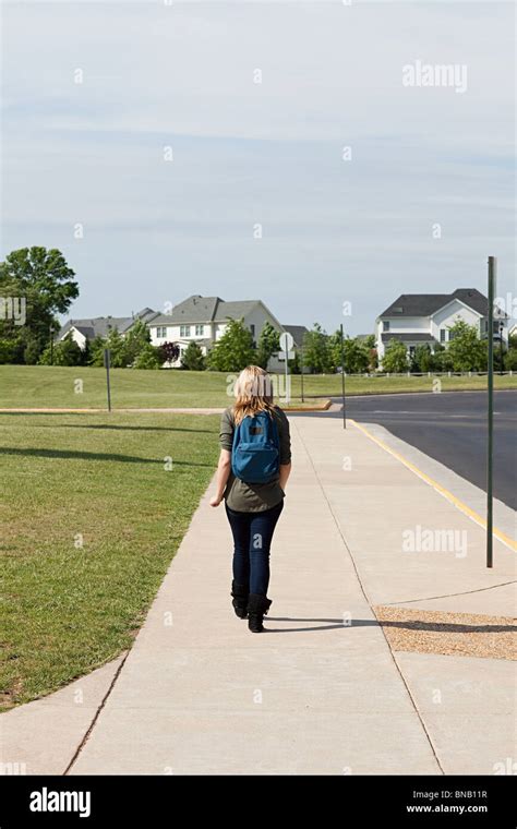 Female High School Student Walking Along Pavement Stock Photo Alamy