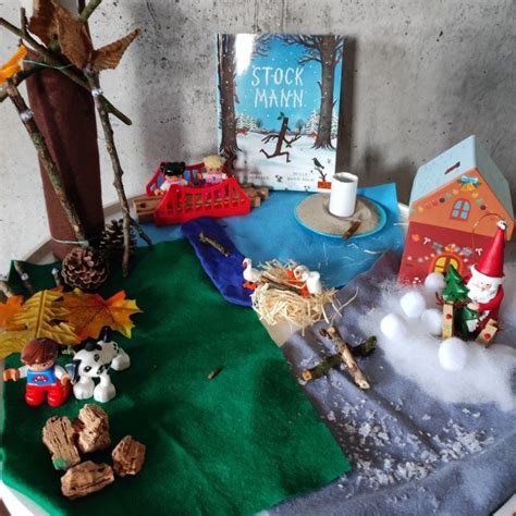 A Table Topped With Toys And Books On Top Of A Green Cloth Covered