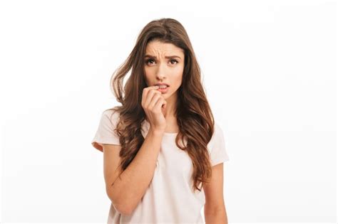 Premium Photo Worried Brunette Woman In T Shirt Bites Her Fingers Over White Wall