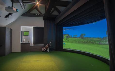 A Man Is Playing Golf On A Large Screen In A Room With Green Carpet And