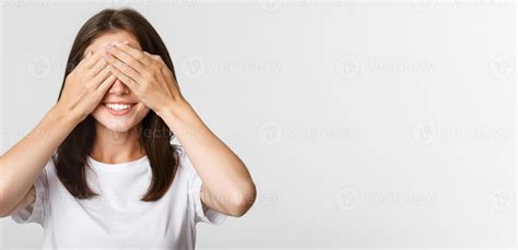 Portrait De Souriant Excit Brunette Fille Proche Yeux Et Attendre Pour Surprise Photo