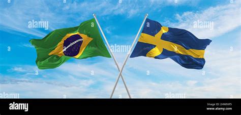 Crossed National Flags Of Brazil And Sweden Flag Waving In The Wind At