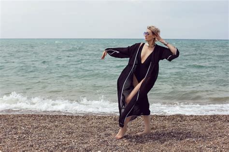 Premium Photo Sexy Woman In A Black Swimsuit And Sunglasses Is Stand