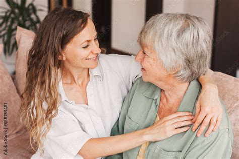 Older Mature Mother And Grown Millennial Daughter Laughing Embracing