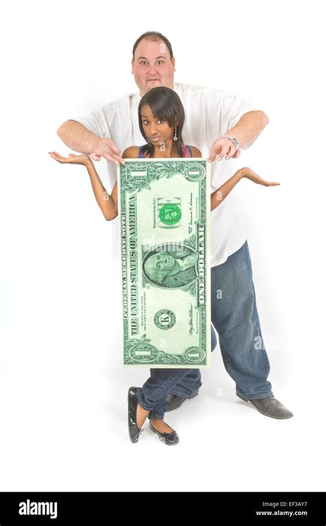 Couple standing behind oversized dollar bill Stock Photo - Alamy