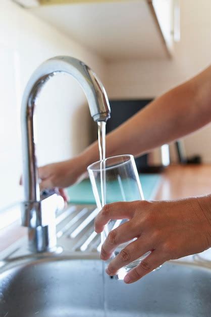 Mujer Llenando Un Vaso De Agua Fr A En El Grifo De La Cocina Foto Premium