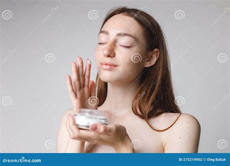 Studio Portrait Of A Woman Holding Jar With Face Cream Stock Photo