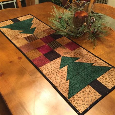 a wooden table topped with a christmas tree runner