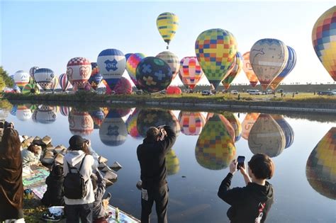 嘉瀬川の水面に映るバルーンを写真に撮る人たち 佐賀バルーンフェスタ開幕 早朝の空に「一斉離陸」 写真・画像13｜【西日本新聞me】