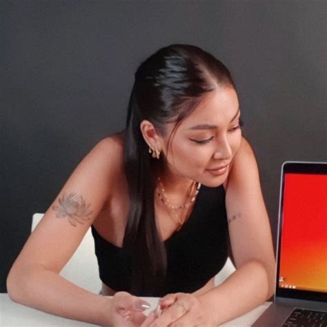 A Woman Sitting At A Table With A Laptop Computer On Her Lap And