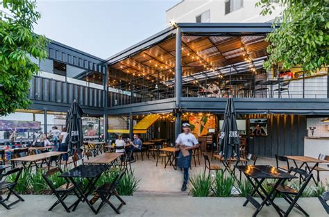 Urban Shipping Container Restaurant With A Beautiful Wooden Pergola