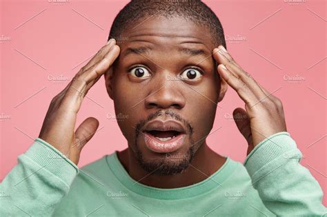 Close Up Portrait Of Bug Eyed Stupefied Black Man Keeps Hands On Head