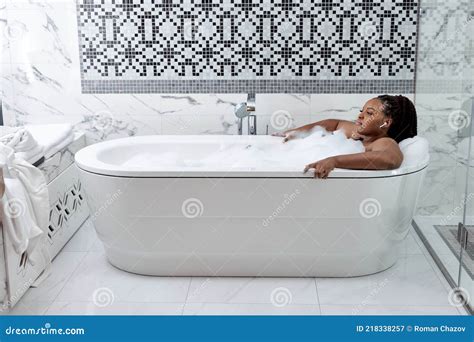 Relaxed African Woman Taking Bath With Foam With Pleasure Enjoying Spa