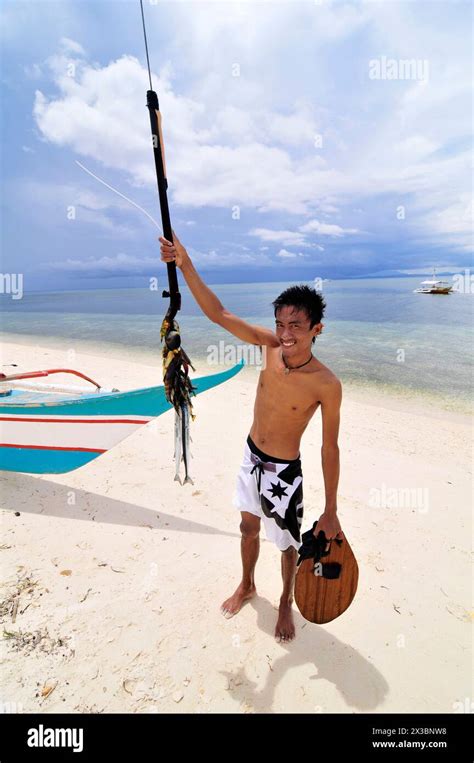 A Filipino Man Showing His Caught Fish On A Spear Malapascua Island