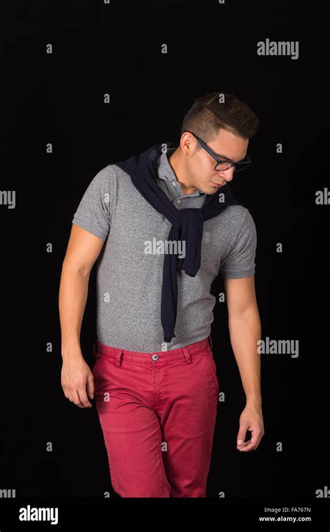 Hispanic Male Wearing Tight Shirt Sweater Over Shoulders Red Pants And Glasses Portraying