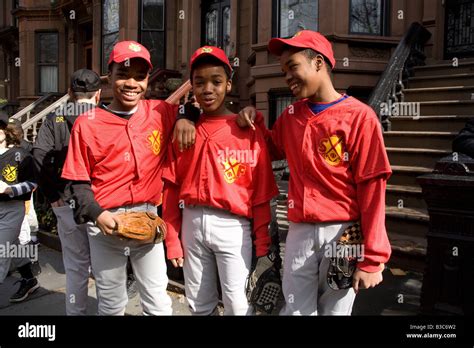 Triplets, two boys and a girl, ready to play ball on opening day of Little League baseball ...