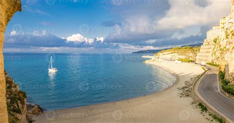 Tropea town and beach, yacht boat in Tyrrhenian Sea, colorful buildings