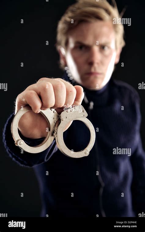 Cop Showing Handcuffs For Those Offenders Of The Law Stock Photo Alamy