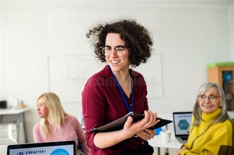 Portrait Of Teacher With Seniors Attending Computer And Technology