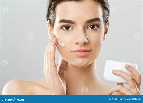 Beauty And Spa Concept Beautiful Model Applying Cosmetic Cream On Her