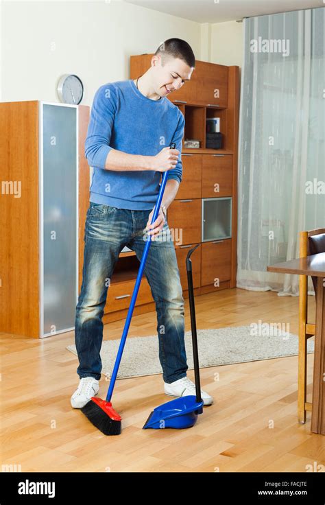 Man Sweeping The Floor In Living Room At Home Stock Photo Alamy