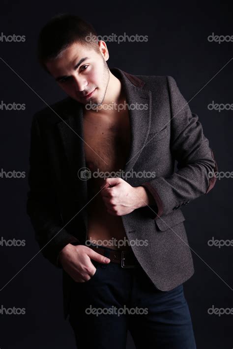 Handsome young man on dark background — Stock Photo © belchonock #41768877