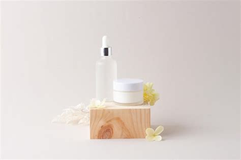 Premium Photo Cosmetic Skin Care Products With Wood Podium And Flowers On Grey Background